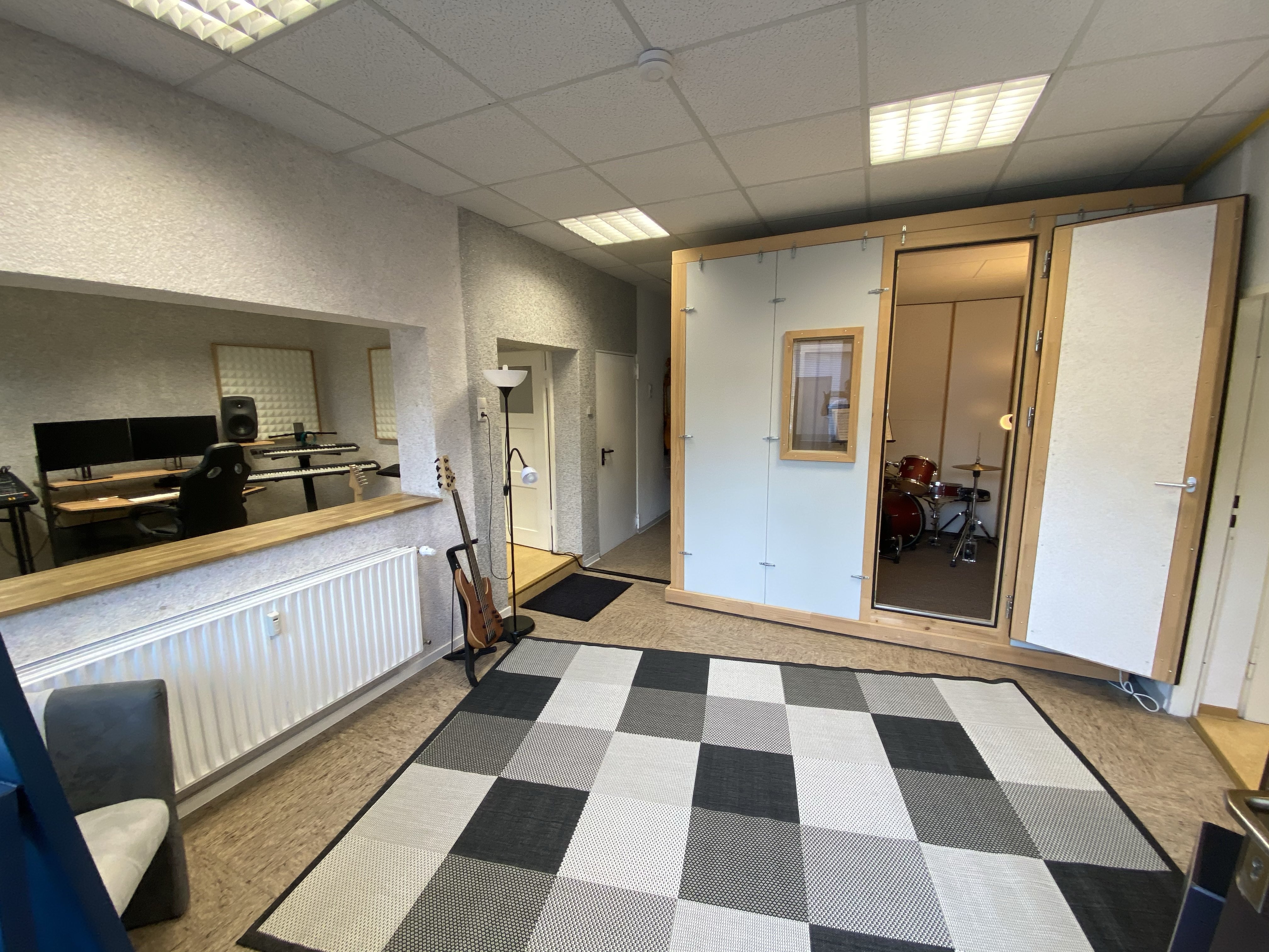 Back of a man at a concert. Hes wearing a beanie hat and a baggy denim jacket with studs. Photo with a purple hue